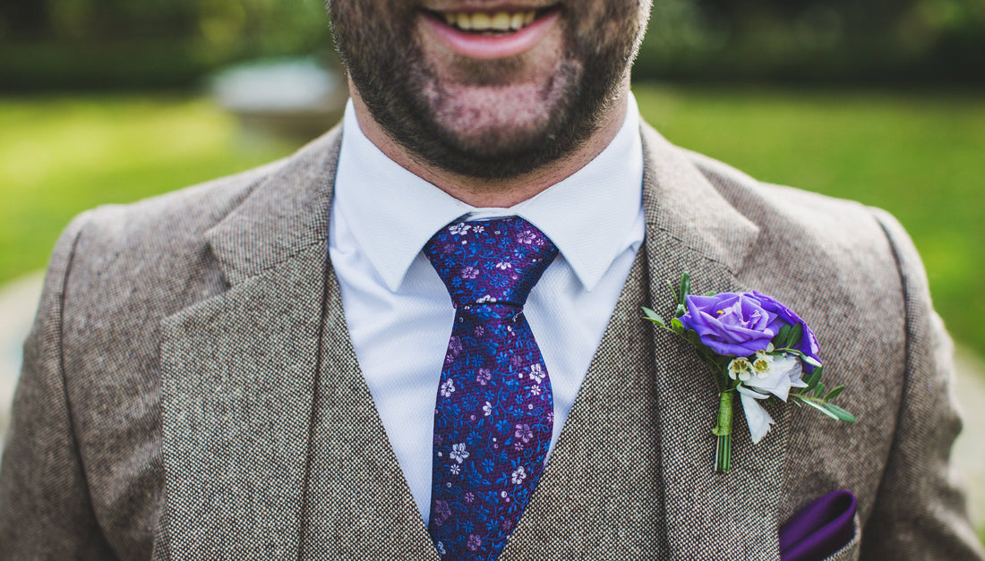 Close up of man wearing grey tweed suits, top of head cut off and chest is visible